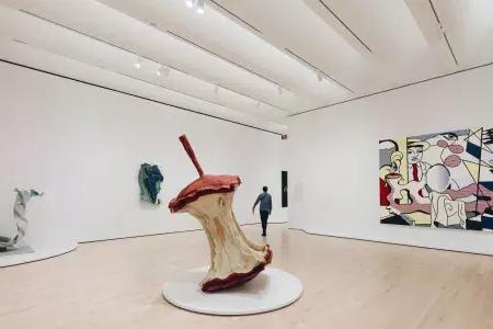 在贝博体彩app现代艺术博物馆，一名男子走过一个宽敞通风的展览室，里面摆满了现代艺术品. 贝博体彩app, California.